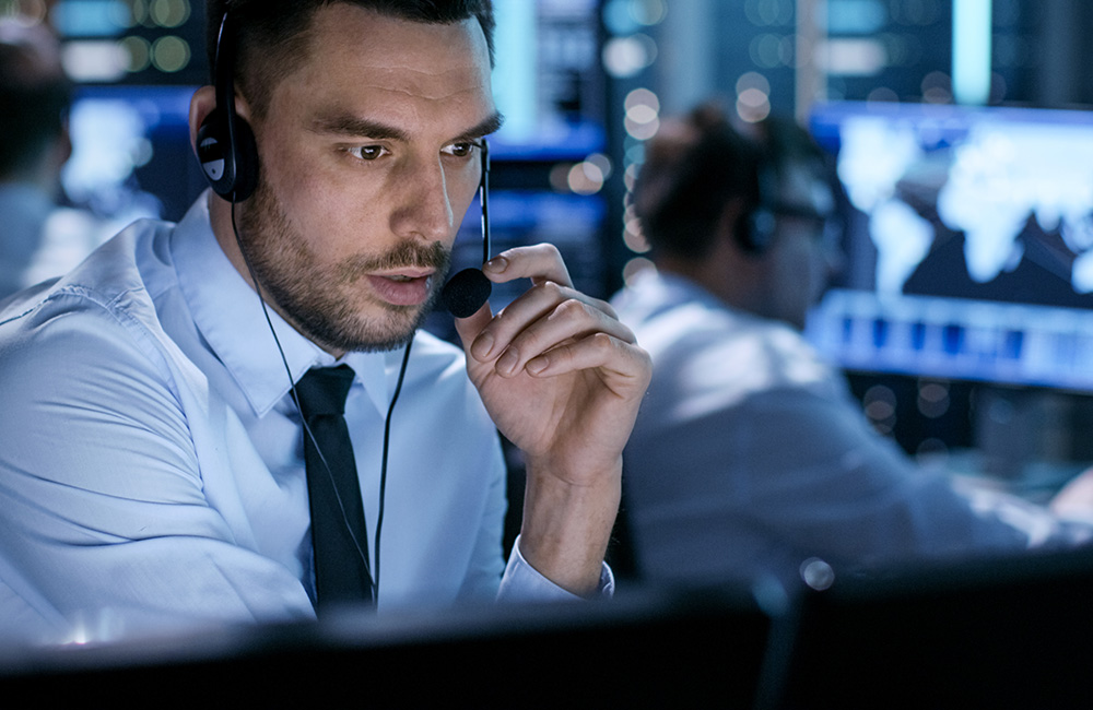 Private security consultant in a control room carrying out employee manpower surveillance monitoring and investigations in UK